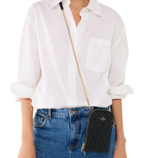 A person is wearing a white button-up shirt and blue jeans, with a black quilted crossbody bag featuring a gold chain strap.