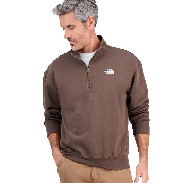 A man is wearing a brown quarter-zip pullover from The North Face, paired with khaki pants.