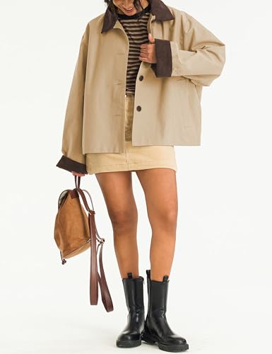 A person is wearing a beige jacket with dark brown collar and cuffs, a striped shirt, a beige skirt, black boots, and holding a brown backpack.