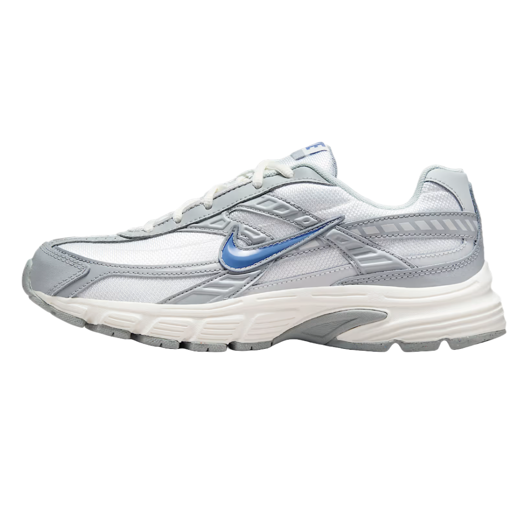 A sneaker with a primarily white and gray color scheme, featuring a blue Nike swoosh. The design includes a textured sole and layered paneling.
