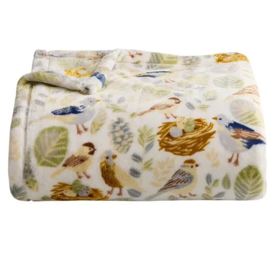 A folded, plush blanket features a whimsical pattern of birds, nests, and foliage in soft, natural colors.