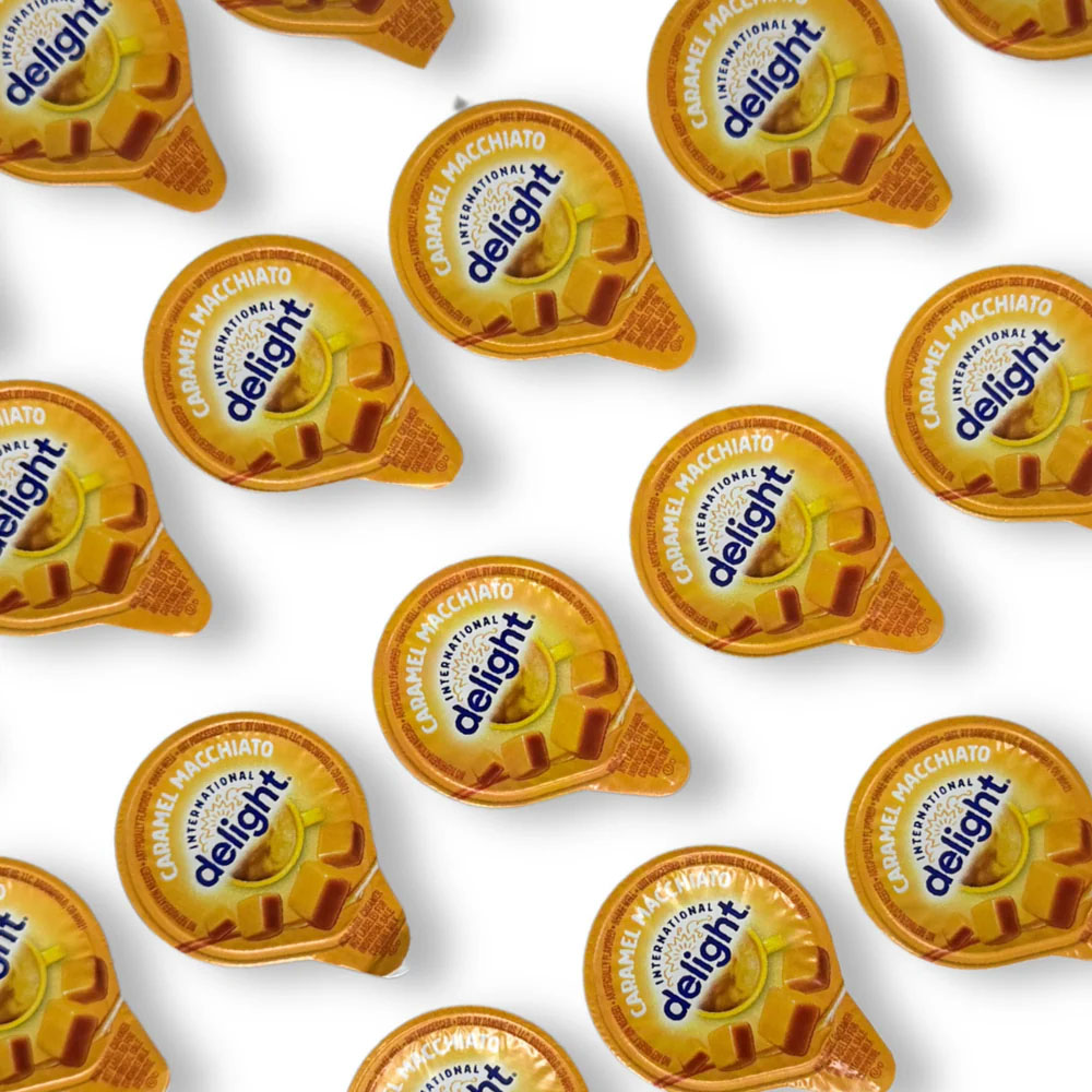 Caramel Macchiato coffee creamer cups from International Delight arranged in a pattern.