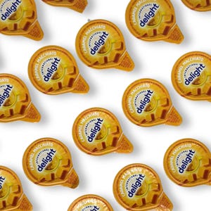 Caramel Macchiato coffee creamer cups from International Delight arranged in a pattern.