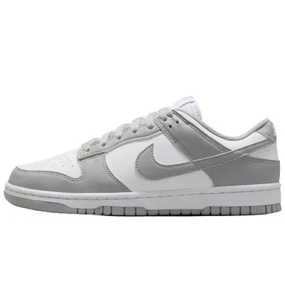 A low-top sneaker in white and grey tones with a distinctive logo on the side, featuring a lace-up design and perforated toe box for breathability.