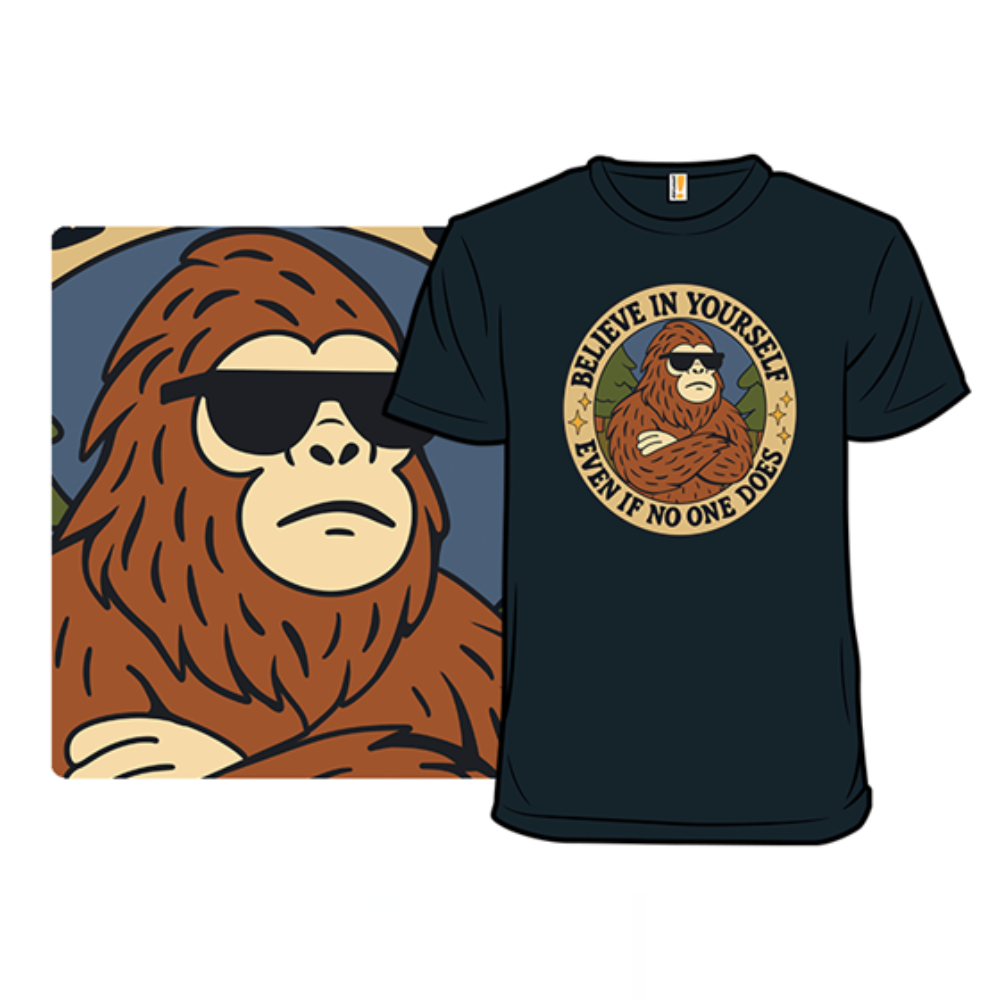 A black t-shirt features a graphic of a cool Bigfoot wearing sunglasses with the text \“Believe in yourself even if no one does\“ surrounding the image.