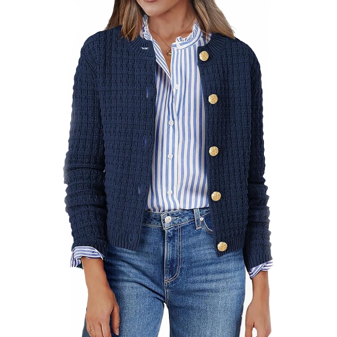 A woman wears a textured navy cardigan with gold buttons over a blue and white striped blouse, paired with blue jeans.