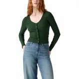 A person is wearing a fitted, long-sleeve green cardigan with buttons, paired with high-waisted blue jeans.