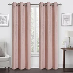 Room with pink curtains on a metal rod, flanked by two framed pictures. A lamp and flowers rest on a side table, with an armchair on the opposite side.