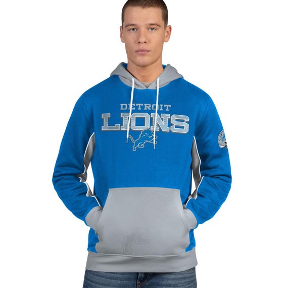 A person wearing a blue and gray Detroit Lions hoodie with a front pocket and logo on the sleeve.