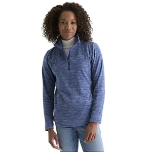 Woman wearing a blue quarter-zip pullover with a white turtleneck underneath, paired with light blue jeans.