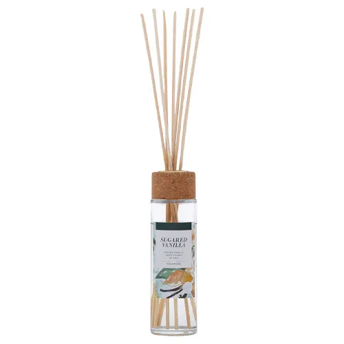 Reed diffuser with a cork lid, labeled \“Sugared Vanilla,\“ containing long wooden sticks for dispersing fragrance.