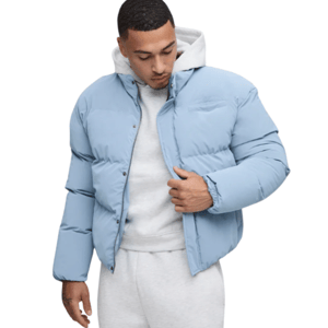 A person is wearing a light blue puffer jacket over a gray hoodie and matching sweatpants.