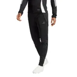 Black Adidas sportswear featuring three stripes on the sleeves and pants, paired with white athletic shoes.