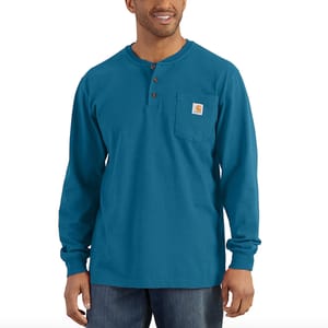 A man wearing a blue long-sleeved Henley shirt with a chest pocket.
