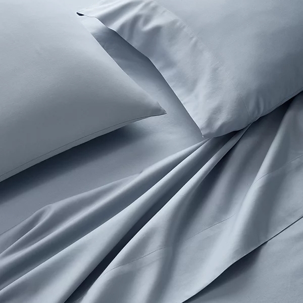 Light blue bed sheets and pillowcases with a smooth texture are displayed, suggesting a soft and comfortable fabric.