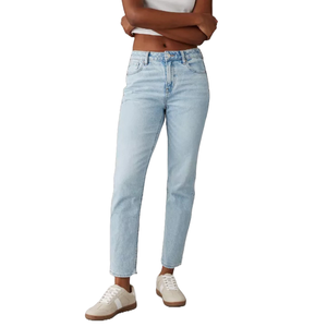 AE Strigid Mom Jean features a high-waisted, slightly relaxed fit in a light blue wash, paired with a simple white tank top and white sneakers with tan soles.