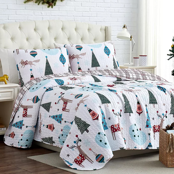 A holiday-themed quilt set with matching pillowcases, featuring Christmas trees, reindeer, and snowman patterns.