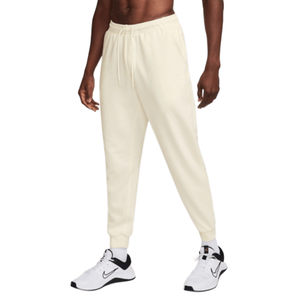 Cream-colored joggers with an elastic waistband and drawstring, paired with white and black Nike sneakers.