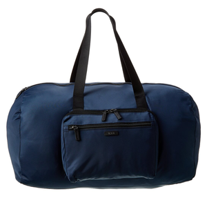 A blue Tumi duffle bag with black handles and a front zippered pocket, featuring sleek, minimalist design suitable for travel or gym use.