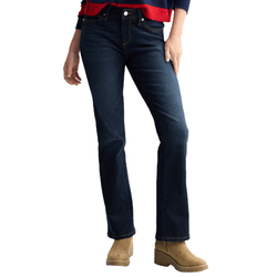 A person wearing dark blue bootcut jeans and tan suede boots, paired with a red and navy sweater.