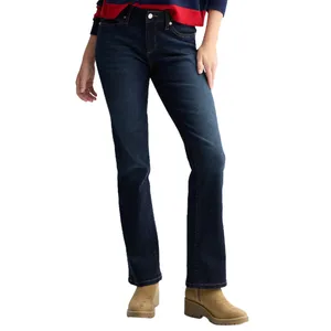 A person wearing dark blue bootcut jeans and tan suede boots, paired with a red and navy sweater.