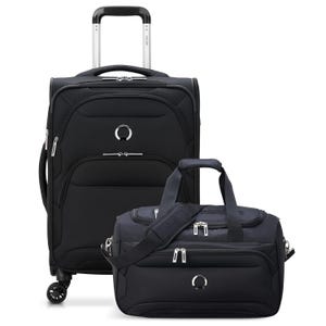 Two black pieces of luggage from Delsey Paris: a wheeled carry-on suitcase and a duffel bag. Both feature silver zippers, a circular logo, and reinforced handles, with the suitcase also having an extendable handle and four wheels for easy transport.