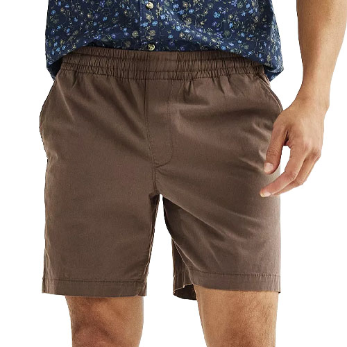 A person is wearing brown shorts with an elastic waistband and side pockets, paired with a blue floral shirt.