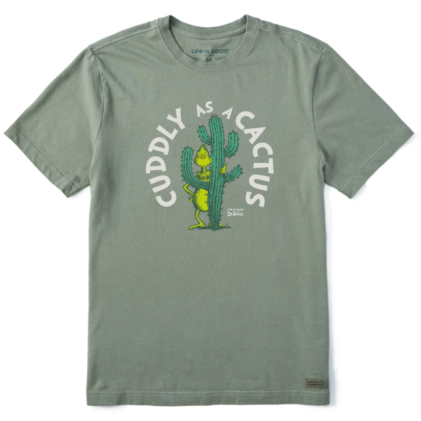 A green T-shirt with the text \“Cuddly as a Cactus\“ and an illustration of a character hugging a cactus, featuring Life is Good and Dr. Seuss branding.