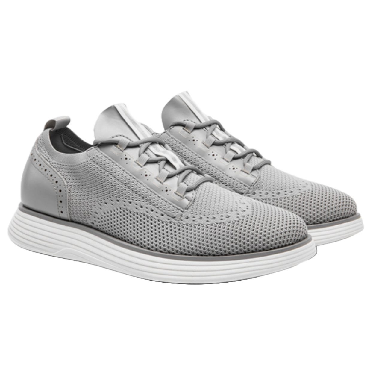 Gray athletic shoes with a knit texture, featuring lace-up design and perforated accents, on a white cushioned sole.