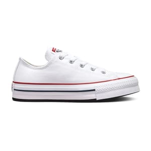 White low-top canvas sneaker with red and blue stripe accents on the sole and metal eyelets for laces.