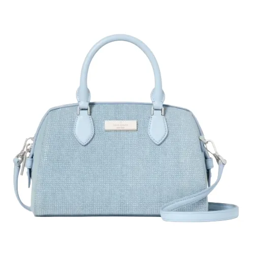A light blue textured handbag with dual handles and a detachable shoulder strap, featuring a metallic logo plate on the front.