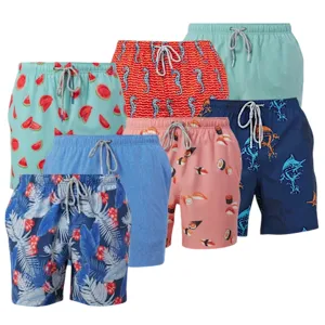 A collection of vibrant swim trunks featuring patterns like watermelon, fish, toucans, pineapples, and dinosaurs, in various shades of blue, pink, red, and green, with drawstring waists.
