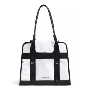 White and black tote bag with long textured handles, featuring The North Face logo and buckled front strap detailing.