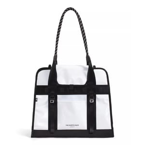 White and black tote bag with long textured handles, featuring The North Face logo and buckled front strap detailing.