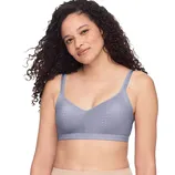 A woman is wearing a gray, lightly textured bralette with adjustable straps, paired with beige bottoms.