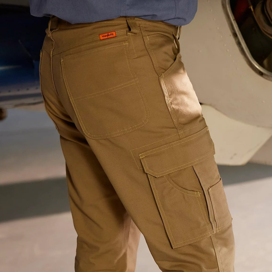Khaki cargo pants with multiple pockets, featuring a logo tag on the back pocket, paired with tan boots.