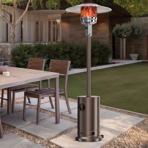 48,000 BTU patio heater with a sleek metallic finish, flame visible under a large reflector dome, and equipped with wheels for easy mobility, positioned on a stone patio alongside outdoor dining furniture.