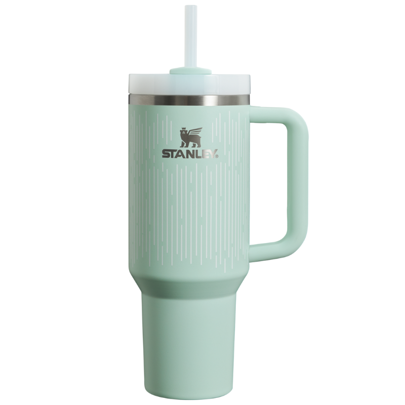 The 40oz Quencher H2.0 Tumbler is a mint green drink container with a handle, a clear straw, and a stainless steel band near the lid. It features the Stanley logo and vertical line design elements.