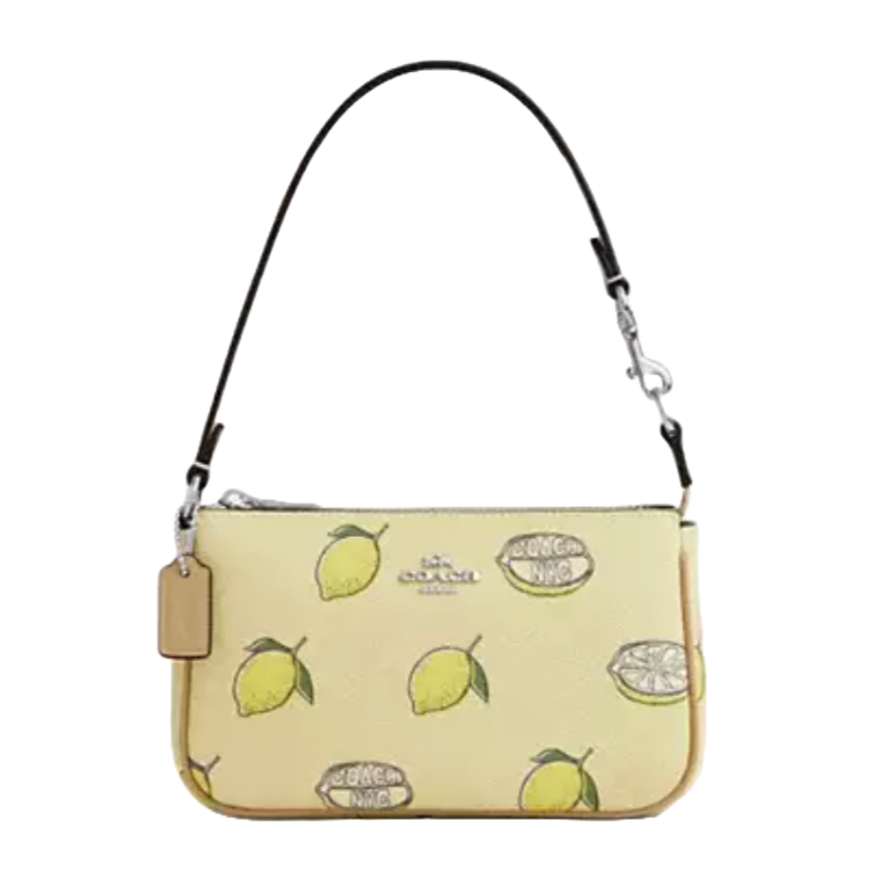 A small Coach handbag featuring a lemon motif on a light yellow background with a detachable black strap.