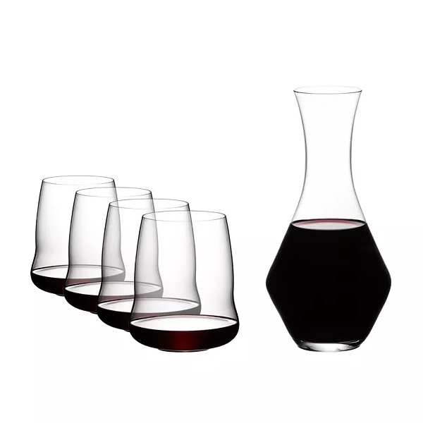 A set of four stemless wine glasses with red wine and a matching wine carafe.