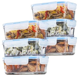 Glass food storage containers with blue airtight lids, stacked and filled with assorted foods like vegetables and meat.