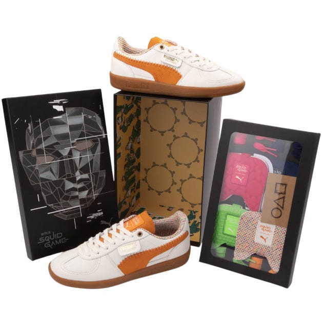 PUMA x Squid Game collaboration featuring white and orange sneakers, with themed packaging and accessories like colorful socks.