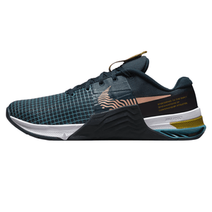 A dark blue athletic shoe with a grid pattern, featuring a graphic swoosh and the text \“Engineered to the exact specifications of championship athletes\“ on the side. It has a textured sole with layered colors and a woven loop on the tongue.