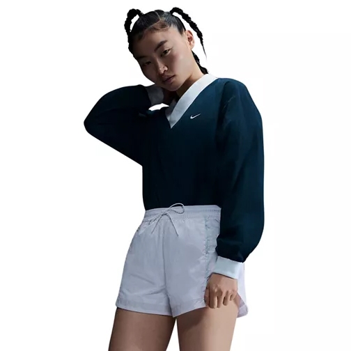 Nike Women's Woven V-Neck Top features a dark navy design with a white collar and logo, providing a classic, sporty look. It's paired with white shorts, creating a stylish contrast.