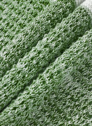 A close-up of green and white textured fabric with a knitted pattern, showing detailed interwoven threads.