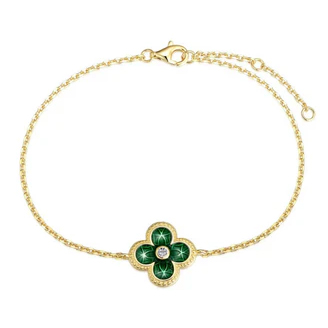A gold chain bracelet featuring a green clover-shaped charm with a central diamond and a lobster clasp closure.