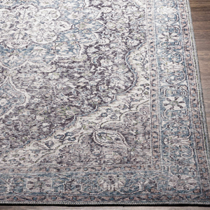 A 9' x 12' machine-washable area rug featuring a vintage-inspired design with a mix of blue, gray, and cream tones, showcasing intricate floral and medallion patterns on a bordered edge.