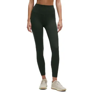 High-waisted, dark green leggings paired with beige sneakers.