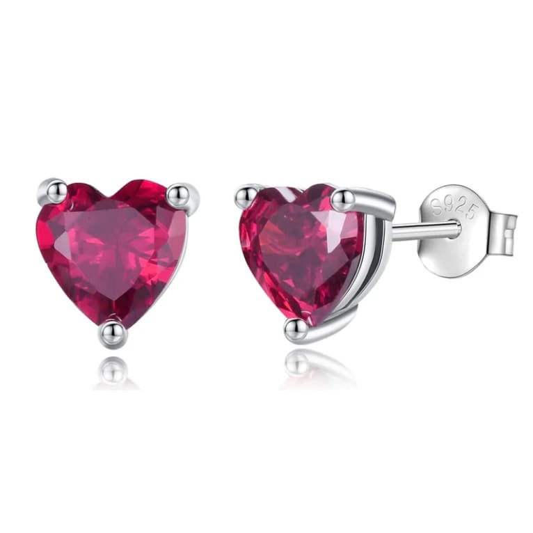 A pair of sterling silver stud earrings featuring heart-shaped, faceted pink gems with a prong setting and butterfly backs.