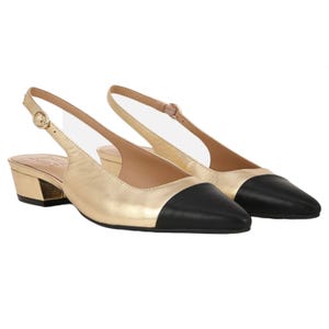 Gold and black slingback flats with a pointed toe and low block heel, featuring an adjustable ankle strap.